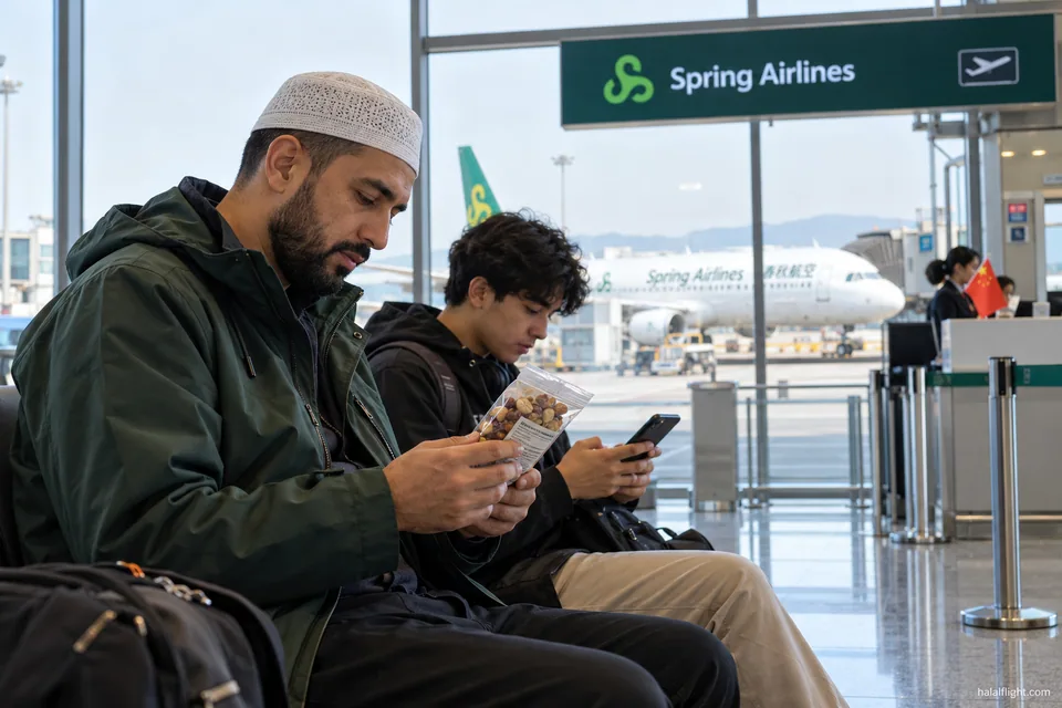 Deux voyageurs consultant leur téléphone près d’une porte d’embarquement dans le terminal d’un aéroport